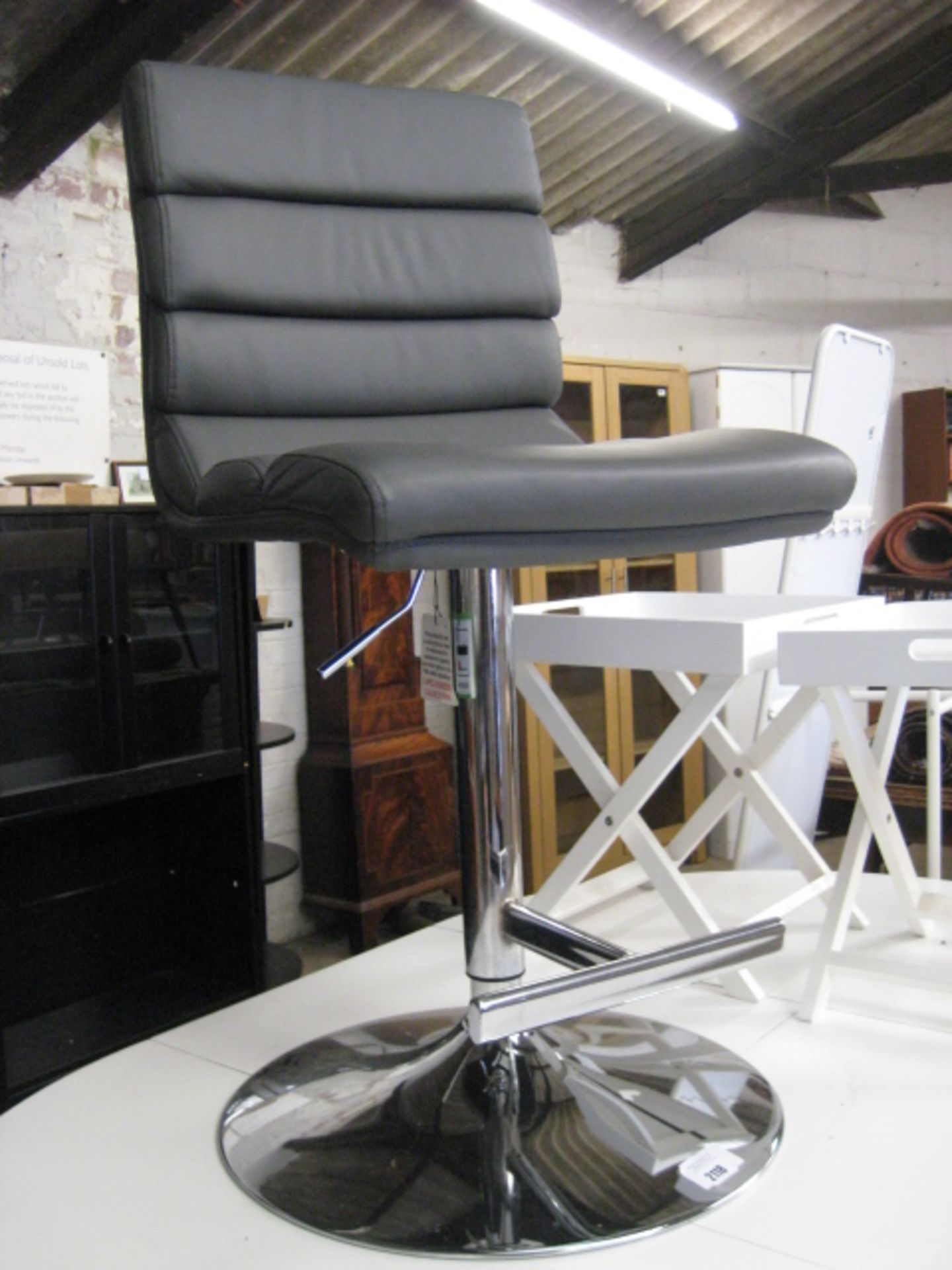 Grey faux leather upholstered rotating chrome base bar stool