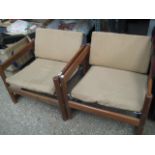 Pair of mid century teak easy chairs with loose yellow cushions