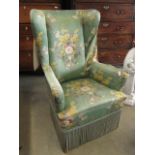 A green floral wing back armchair