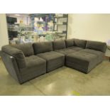 A modular grey fabric sofa in 6 sections, to include a footstool