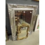 Ornately framed and bevelled wall mirror