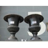 A pair of cast iron urns