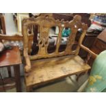 A heavily carved pine two seater bench