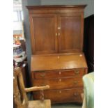 An oak secretaire with three drawers under