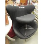 After Arne Jacobsen, a black fabric 'Egg'-type armchair with matching footstool (collectors item,