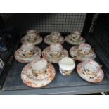 A cage containing a quantity of Country patterned cups & saucers, plus a jug