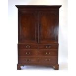 A George III mahogany linen press, the pair of panelled doors over two short and two long drawers,