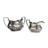 An Edwardian silver two handled sugar bowl with gadrooned decoration and a matching milk jug,