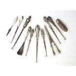 Seven early 20th century silver handled button hooks, a pair of glove stretchers,