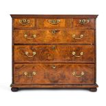 A Georgian walnut and feather crossbanded chest of three short over three long drawers on later bun