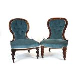 Two Victorian mahogany and button upholstered nursing chairs on turned legs with castors