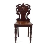 A Victorian mahogany hall chair with an armorial and fretwork back