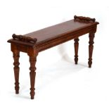 A reproduction mahogany window seat in the Victorian manner with scrolled ends and turned legs