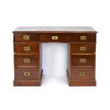 An early 20th century mahogany twin pedestal desk with a tooled leather surface over an arrangement