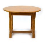 A late 20th century golden oak centre table, the circular surface on four turned supports,