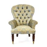 A Victorian button upholstered nursing chair on mahogany feet with castors