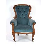 A Victorian mahogany and blue button upholstered armchair with scrolled arms,
