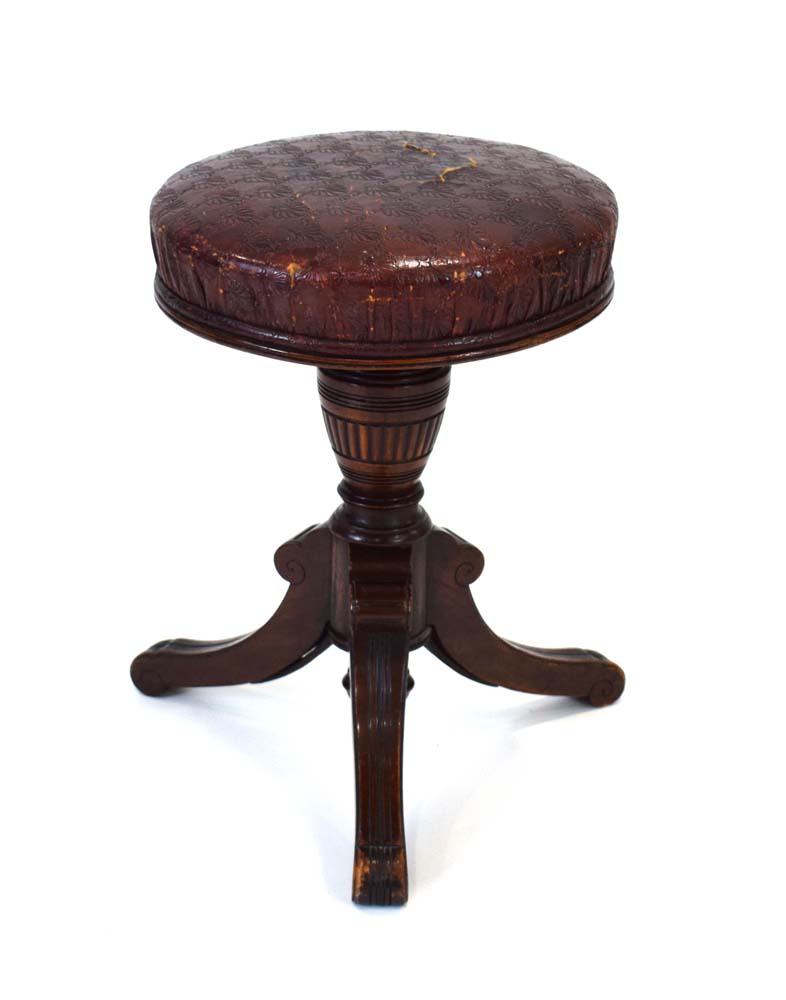 A Victorian mahogany adjustable piano stool with a pressed burgandy seat,