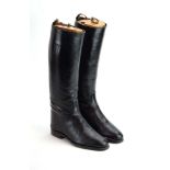 A pair of black leather riding boots with beech and brass mounted trees