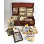 A brown leather case containing a selection of early-to-mid 20th century photographs including