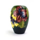 A Moorcroft vase of ovoid form decorated with hibiscus on a shaded green ground,