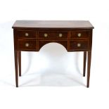 An Edwardian Sheraton Revival bow-fronted mahogany and strung side table with a kneehole apron,