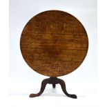 A George II oak tilt-top supper table with a turned column and three splayed legs, d.