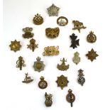 A group of twenty-two various cap badges including The Queen's, The Leinster,