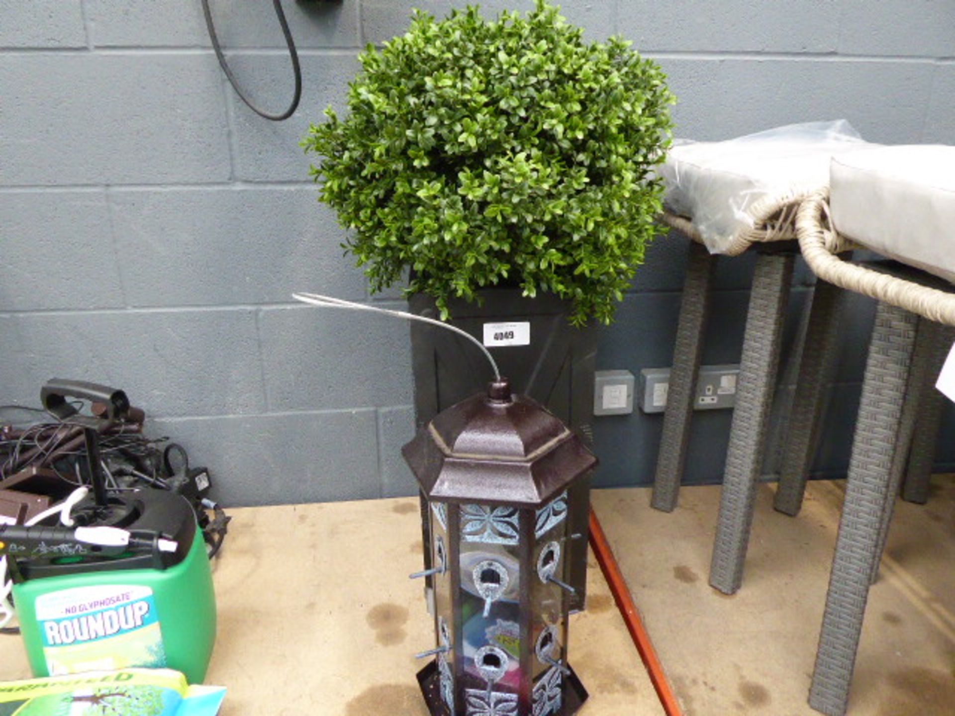 Artificial plant in a resin planter and a bird feeder