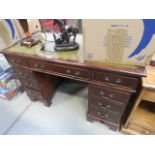 A reproduction mahogany twin pedestal desk, with green leather surface