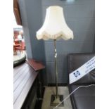 A brushed metal floor lamp with fluted column