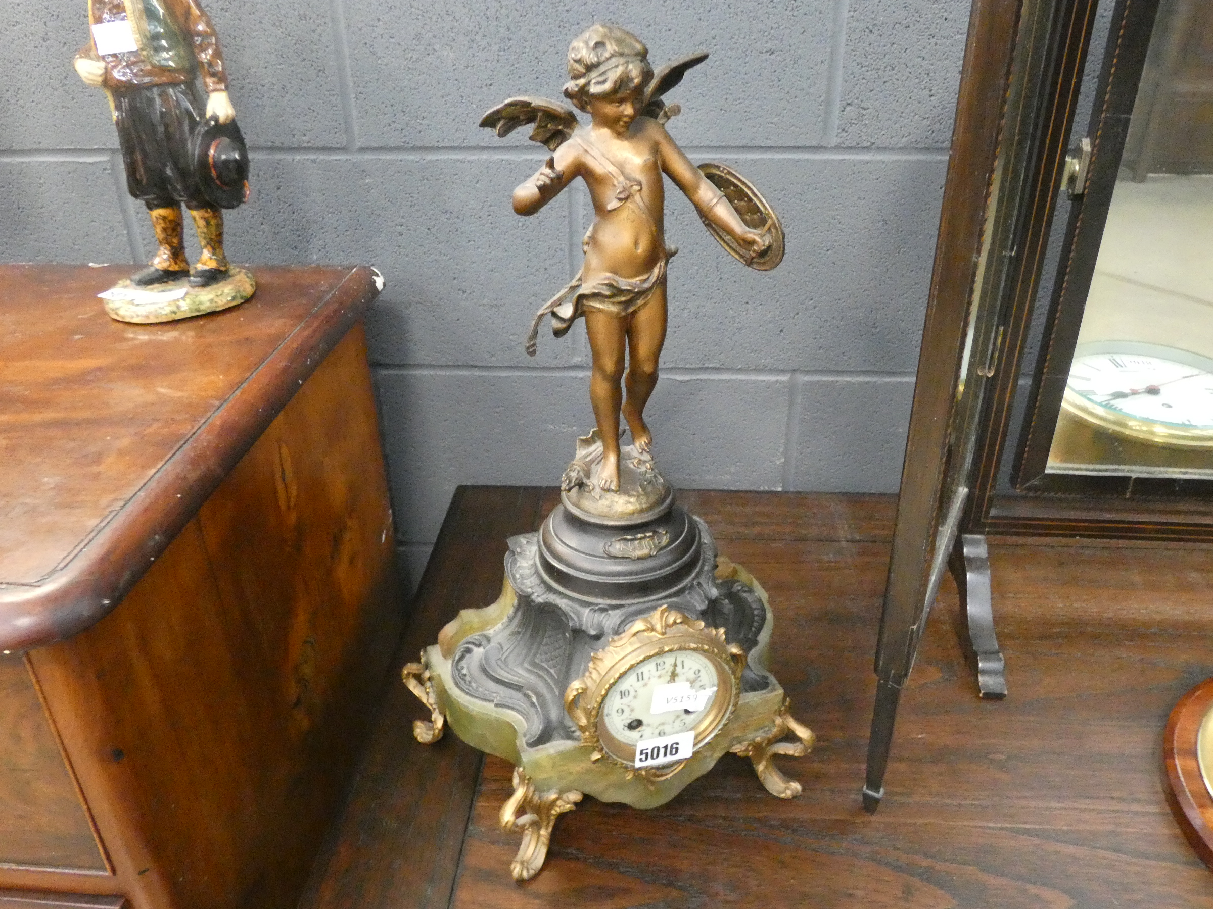 Gilt clock on marble stand with winged cherub decoration