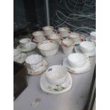 A quantity of cups and saucers plus sugar bowl and milk jug