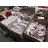 Six boxes containing a large quantity of wine glasses, plus large red glass bowls, a mantle clock,