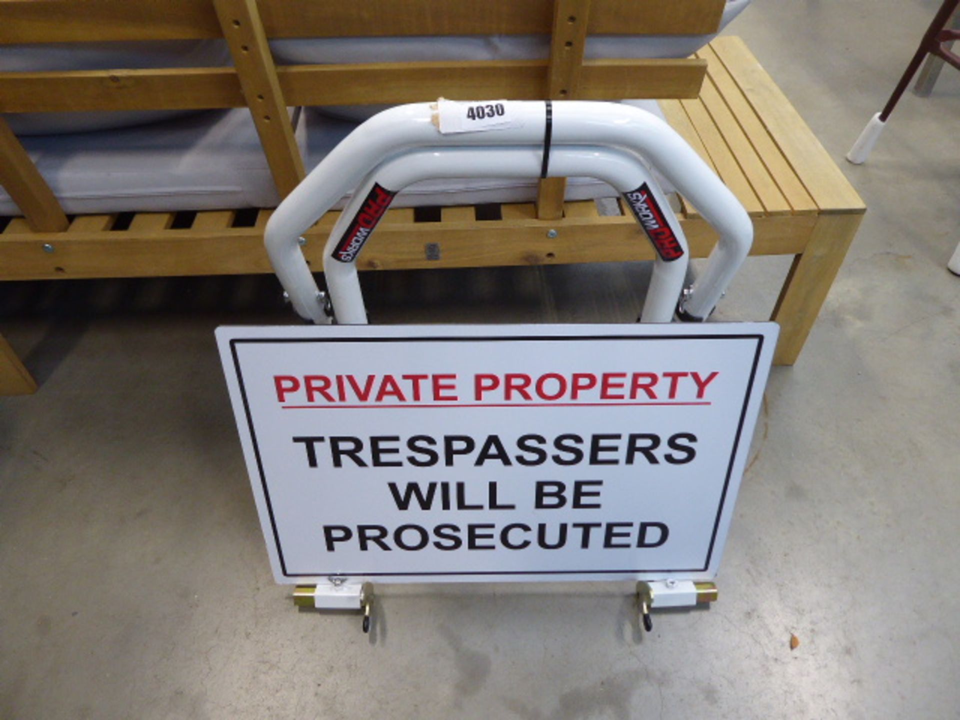 White motorbike stand and a 'Private Property : Trespassers will be prosecuted' sign