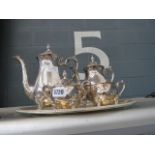 A white metalware tray with coffee pot, sugar bowl and cream jug