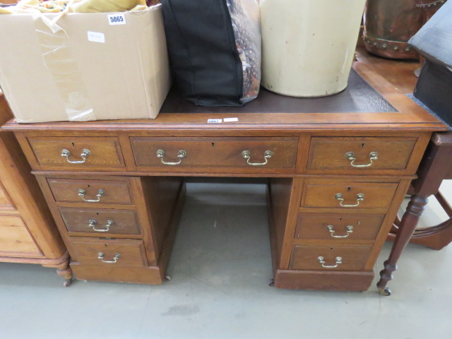 An oak twin pedestal desk with brown leather liner