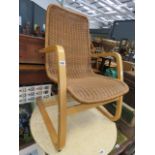 A wicker easy chair on bentwood supports