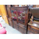 Two door glazed cupboard with two doors under linen fold carving