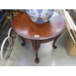 Circular occasional table on four supports in dark wood