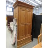A pine two door wardrobe with drawer under