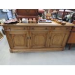 5184 - A dark stained pine three over four door sideboard