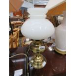 Table lamp in the form of a paraffin light with white opaque shade