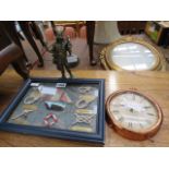 A clock, a framed collection of sailor's knots and a figurine of a Viking