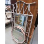 A pink framed florally decorated mirror and a bamboo surround mirror