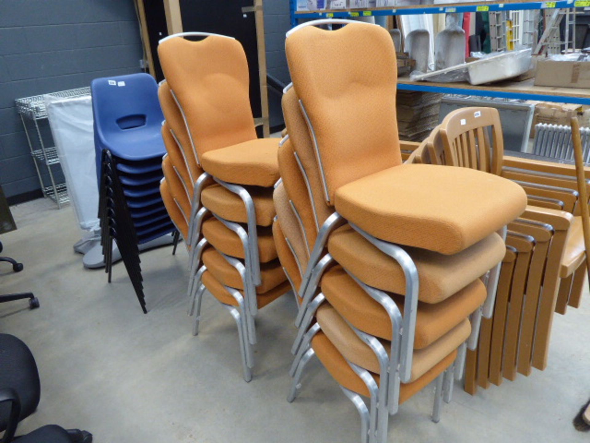 Ten chrome based orange upholstered stacking chairs