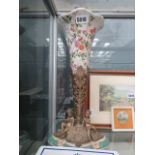 A floral decorated vase in metal stand