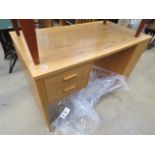 An oak desk with two drawers to the side