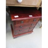 A reproduction mahogany miniature four drawer cabinet, a quantity of cards and gaming pieces