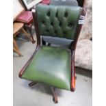 A green leather effect swivel office chair